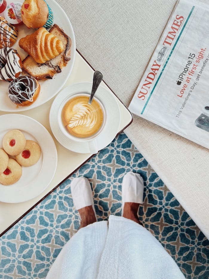 Indulge in a luxurious breakfast with pastries and coffee in an elegant hotel room.